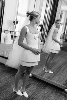 a woman standing in front of a mirror