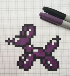 a pen and some type of pixel art on a piece of paper with squares in the background