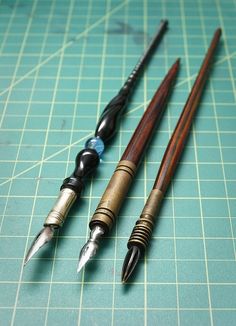 three pens sitting on top of a cutting board