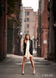 a woman is standing in the middle of an empty street with her hands on her hips