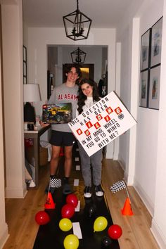 two people are standing in the hallway holding a sign