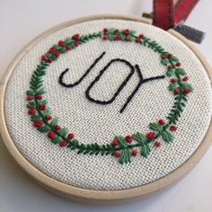 a cross stitch ornament with the word joy written in it