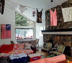 a living room filled with furniture and a fire place covered in clothes hanging from the ceiling