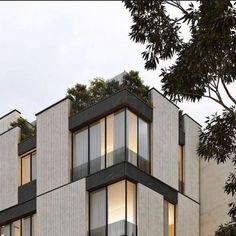 an apartment building with balconies and trees on top