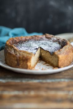 a cake on a plate with one slice cut out and powdered sugar in the middle