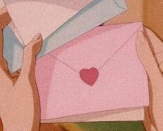 two hands holding an envelope with a heart on it and the other hand is reaching out