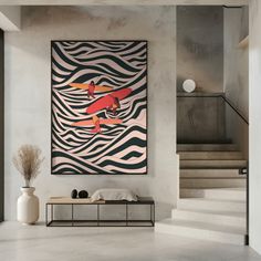 a painting hanging on the wall in a living room next to a stair case and table