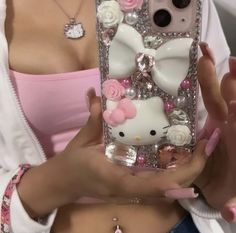 a woman holding a cell phone case with hello kitty on it