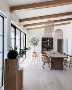 a large dining room with wooden tables and chairs in front of glass doors that look out onto the outdoors