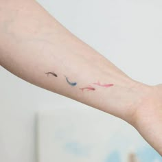 a person's arm with a small tattoo on it