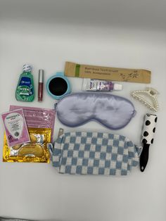 the contents of a travel kit laid out on a white surface, including an eye mask, toothpaste, and other items