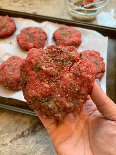 a hand holding up a hamburger pattie