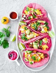 tacos with guacamole, avocado and salsa on a plate