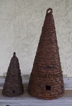 two brown clay cones sitting on top of a wooden table next to a white wall