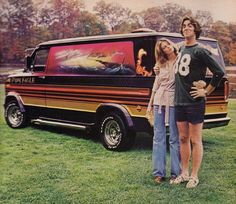 two people standing in front of a van with an advertisement on the back and side