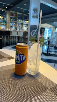 a can and glass on a table in a restaurant