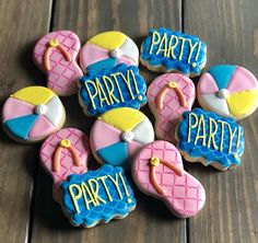 decorated cookies are arranged in the shape of beach balls and flip flops with words party on them