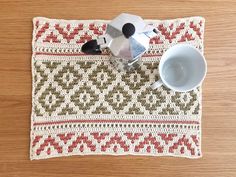 a place mat with a tea pot and cup on it