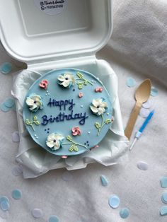 a blue birthday cake with white flowers on it