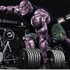 a man with purple paint on his body lifting a barbell