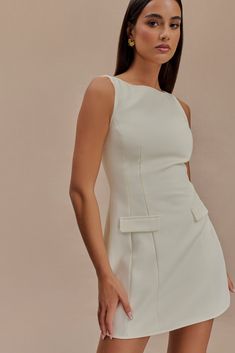 Tailored class. The EVANNA Sleeveless Suiting Mini Dress combines sleek sophistication with a touch of flair. Its boat neckline and fitted bodice create a flattering silhouette, while the flared hem adds movement and elegance. With a mini length and a lined interior for comfort, this dress is both stylish and practical. The centre back zip closure ensures a secure fit, making this dress a chic choice for any occasion where you want to stand out. Chic Tailored Mini Dress With Buttons, Elegant A-line Viscose Mini Dress, Chic Tailored Single-breasted Mini Dress, Luxurious Cream A-line Mini Dress, Feminine Off-white Sleeveless Mini Dress, Closet Essentials, Boat Neckline, Fitted Bodice, Latest Fashion Trends