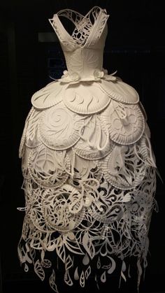 a white dress made out of paper with musical notes on the bottom and back side