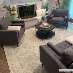 a living room with couches, chairs and a coffee table in front of a fireplace