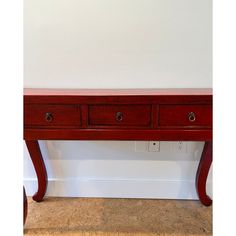 a red wooden table with three drawers