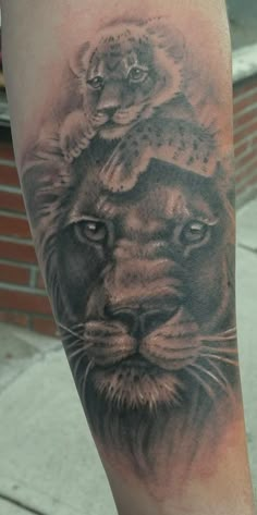 a black and grey tattoo on the leg of a man with a lion head in it