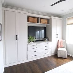 a bedroom with white cabinets and a large tv