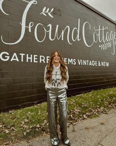 a woman standing in front of a sign that says found cottage gather mes vintage & new