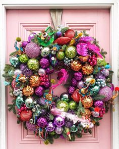 a pink door with a wreath and ornaments on it