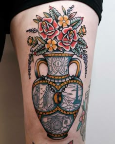 a woman's thigh with a vase and flowers on it