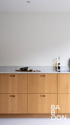 an empty kitchen with wooden cabinets and marble counter tops is seen in this image from the front view