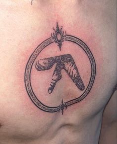 a man with a tattoo on his chest holding a knife in the shape of a circle