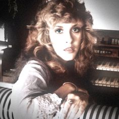 a woman sitting in front of an organ