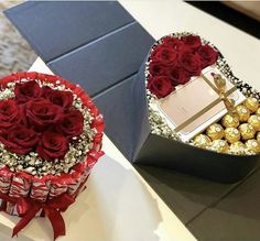 two heart shaped boxes filled with chocolates and roses