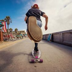 a man riding a skateboard down the middle of a street with his foot in the air