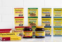 several boxes and packages of food sit on a counter top in front of white tiles