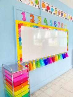 a classroom with a large white board and colorful decorations on the wall next to it