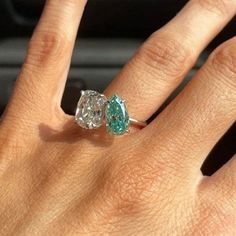 a woman's hand with a ring on it and an emerald stone in the middle