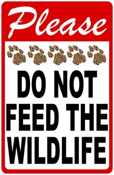 a do not feed the wild life sign with paw prints on red and white background