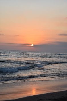 the sun is setting over the ocean with waves