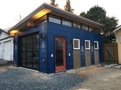 a small blue building with red door and windows