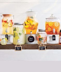 several jars filled with different types of drinks on a shelf next to each other and labels