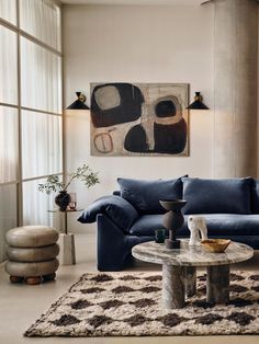 a living room filled with lots of furniture and decor on top of a white rug