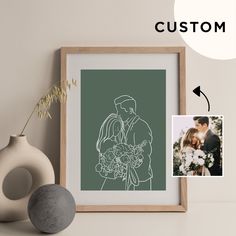 a photo frame with a drawing of a bride and groom on it next to a vase filled with flowers