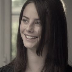 a woman with long hair smiling at the camera