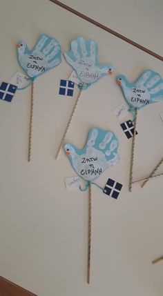 four blue handprinted cake toppers on sticks with flags and name written on them