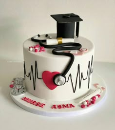 a white cake with a stethoscope on it and a red heart in the middle